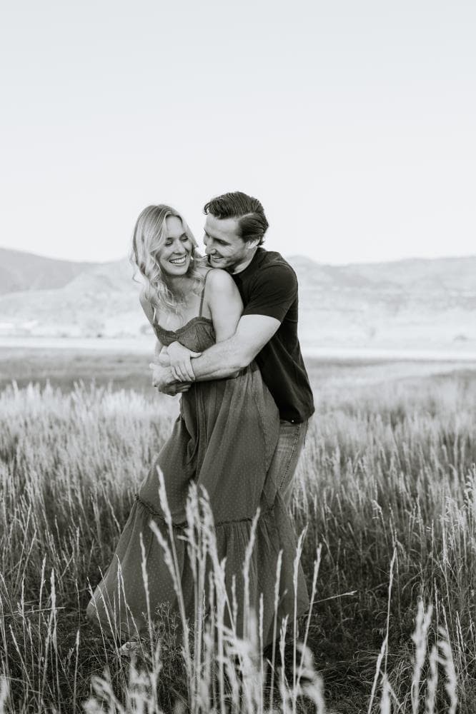 Engagement session couple kissing wildflower field Colorado