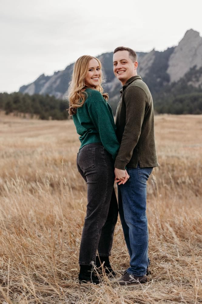 Engagement session couple kissing wildflower field Colorado
