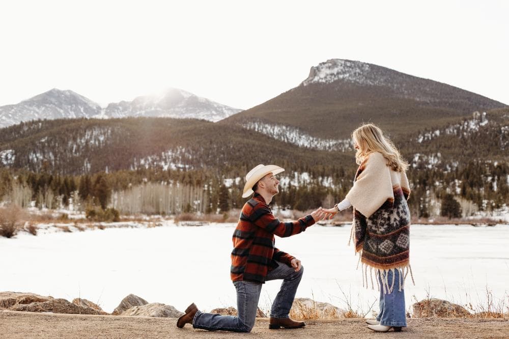 Engagement session couple kissing wildflower field Colorado