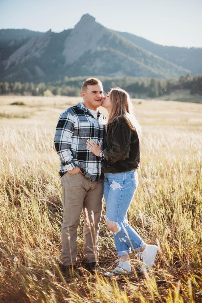 Engagement session couple kissing wildflower field Colorado