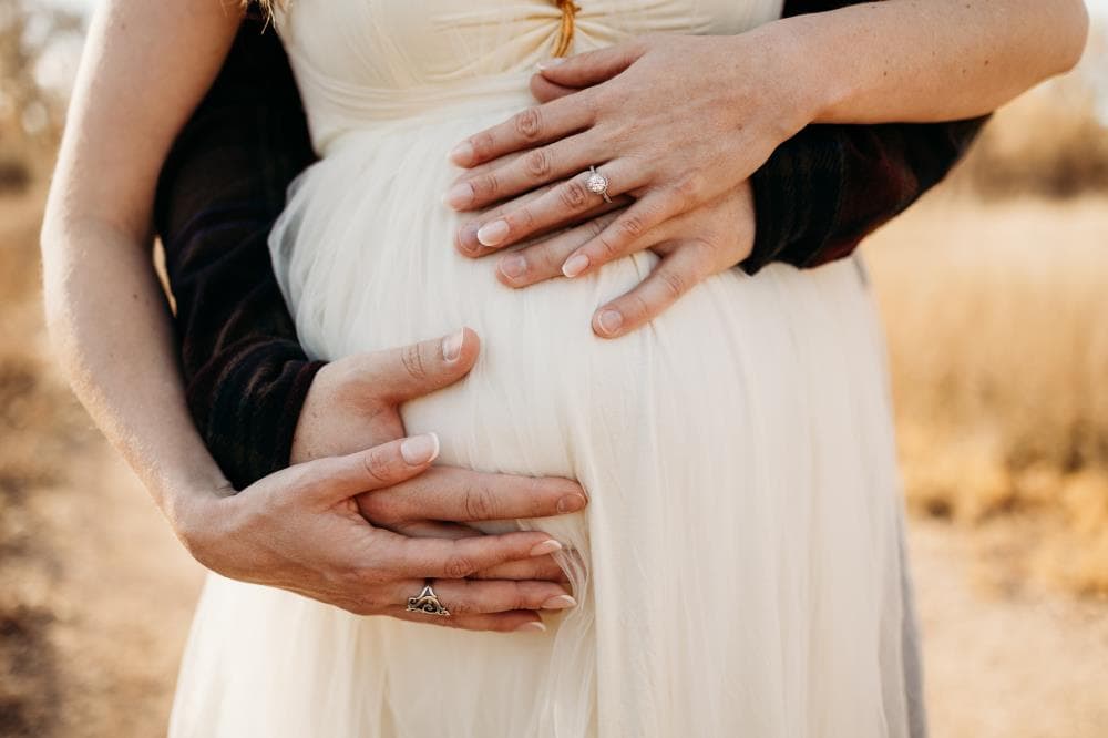 Pregnancy announcement outdoor session wildflower field Colorado