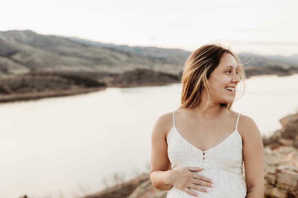 Pregnant mother cradling bump outdoor maternity session Northern Colorado