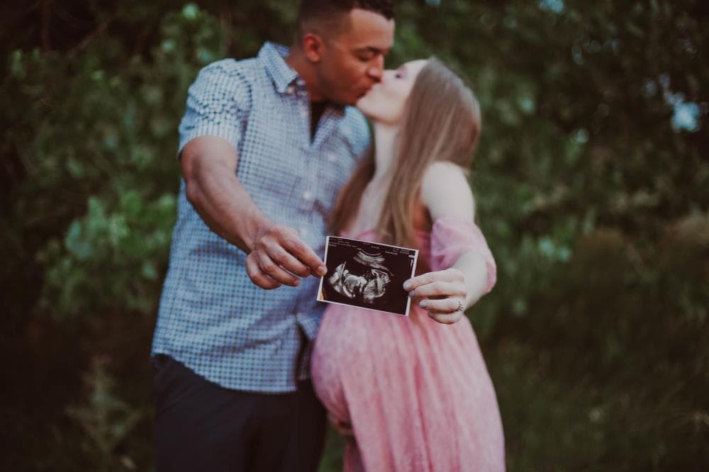 Pregnancy announcement outdoor session wildflower field Colorado