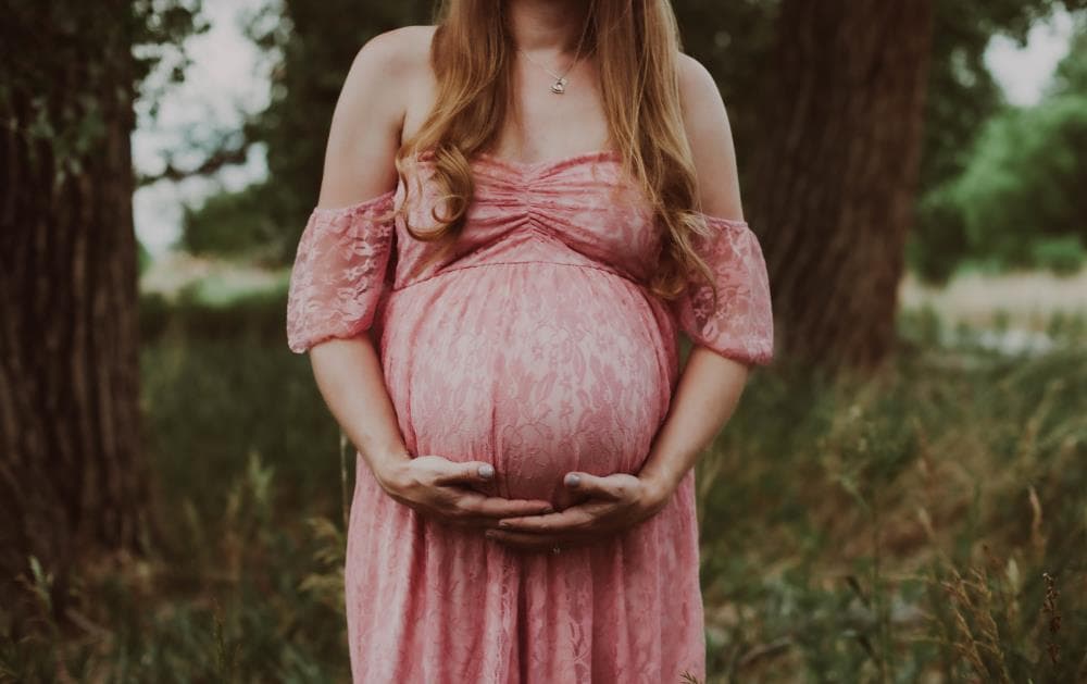 Pregnant mother cradling bump outdoor maternity session Northern Colorado
