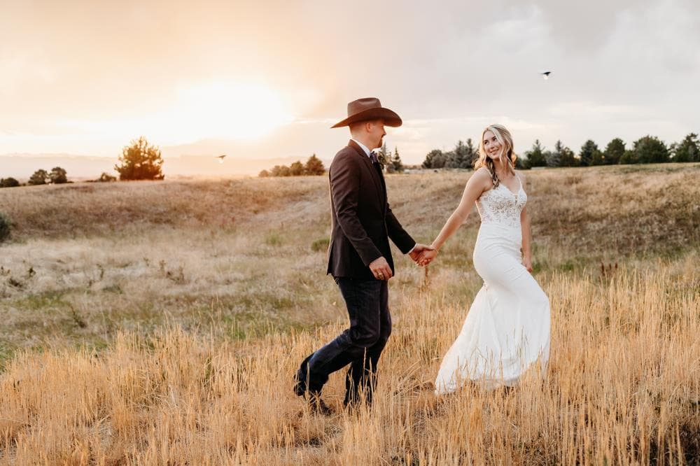 Newlyweds walking hand in hand at sunset Estes Park Colorado