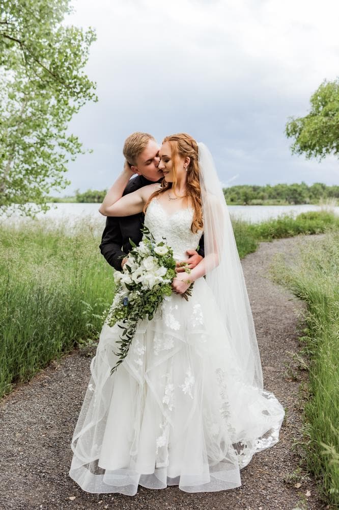 Bride and groom sharing first kiss at outdoor wedding ceremony Colorado
